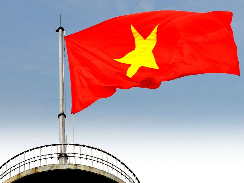 Ảnh cờ đỏ sao vàng tung bay trên cột cờ cao