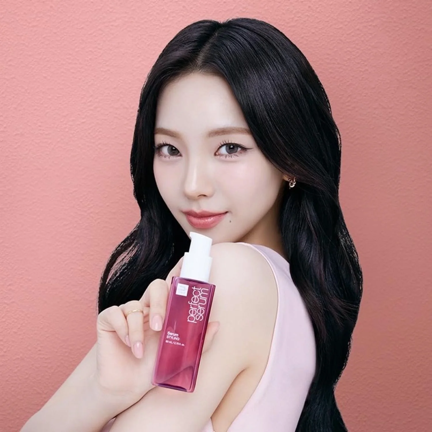 Ảnh bìa Facebook phong cách làm đẹp với cô gái tóc đen cầm chai serum trên nền hồng