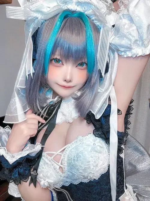 Trong lớp khăn voan trắng, cô gái tóc xanh cúi đầu, diện váy ren anime và nhìn khá tinh nghịch