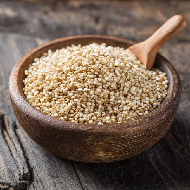 Bát hạt quinoa trắng đặt trên nền gỗ đen
