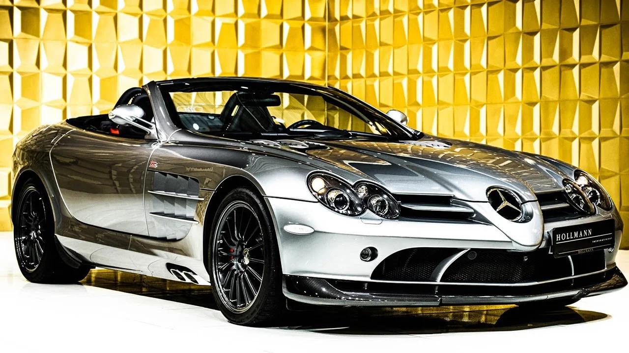 Tranh dán tường họa tiết hình học vàng kim phía sau siêu xe Mercedes-Benz mui trần màu bạc sang trọng.